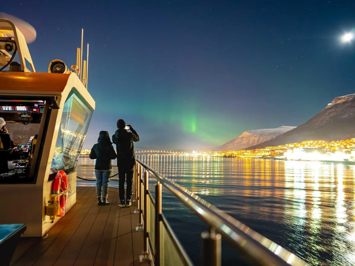 Guests on the deck beneath northern lights