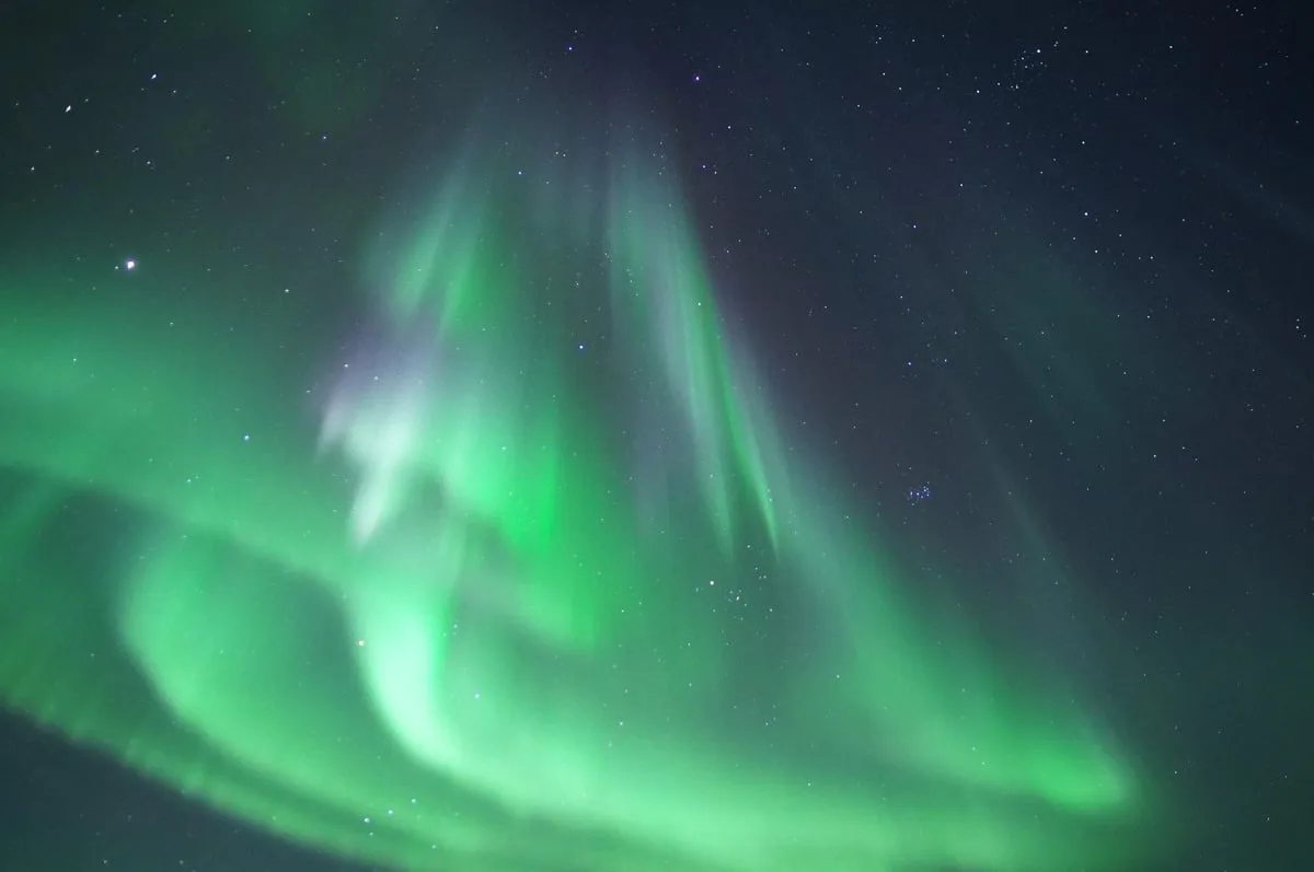 Green northern lights across the night sky