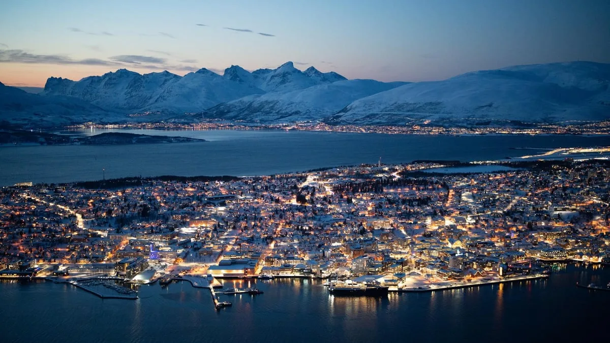 Tromso city and snowy mountains at dusk