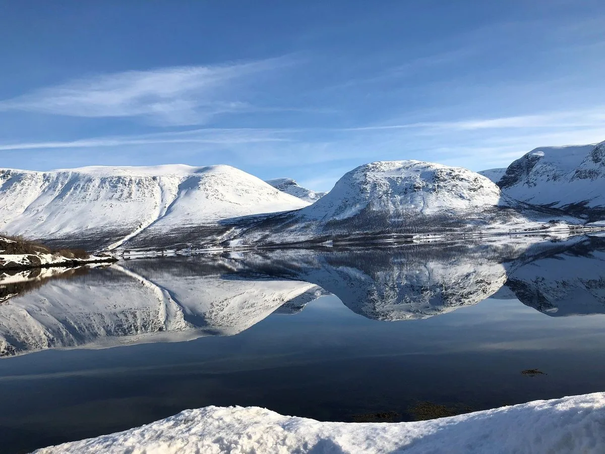 Snow-covered mountains reflected in still water